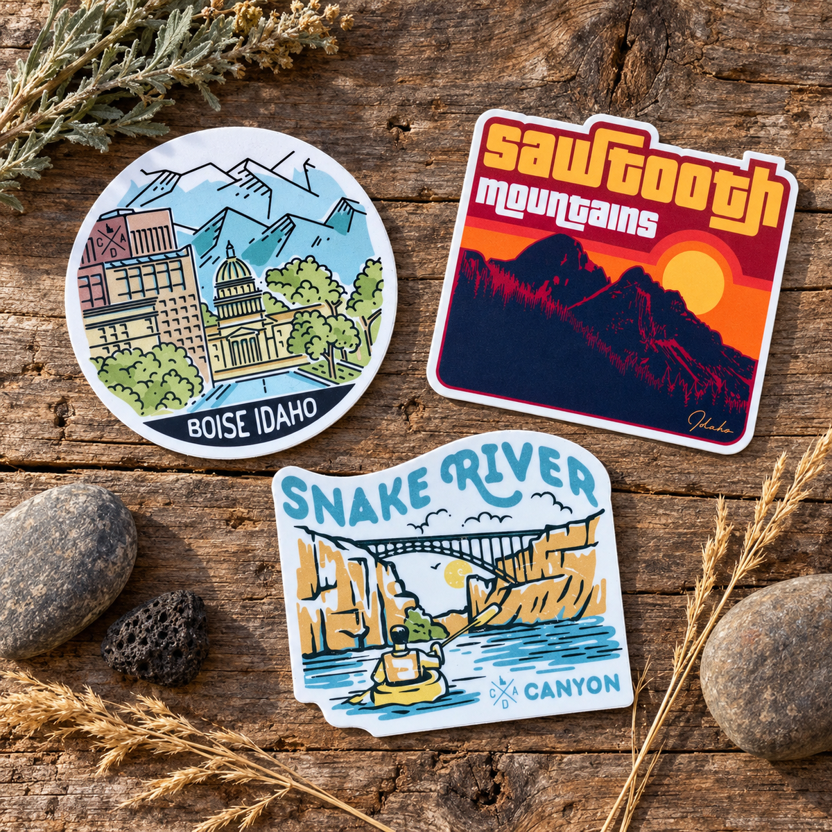 Central and Southern Idaho stickers and gifts arranged on rustic wood