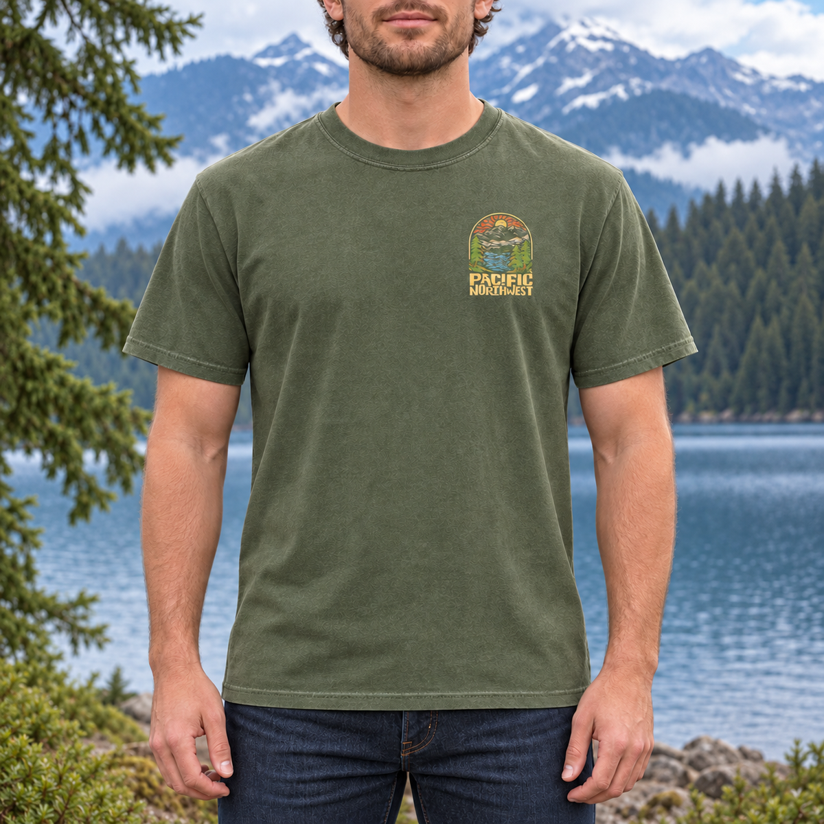 Small left-chest graphic on Hemp Comfort Colors 1717 tee modeled beside a Pacific Northwest mountain lake