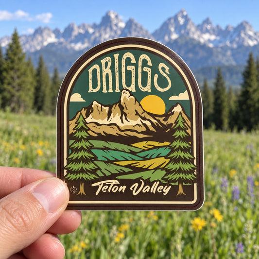 Driggs Teton Valley sticker held outdoors in a mountain meadow near Driggs Idaho
